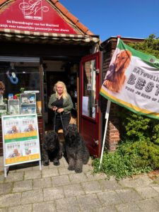 Mireille die met haar bouviers voor een dierenwinkel staat