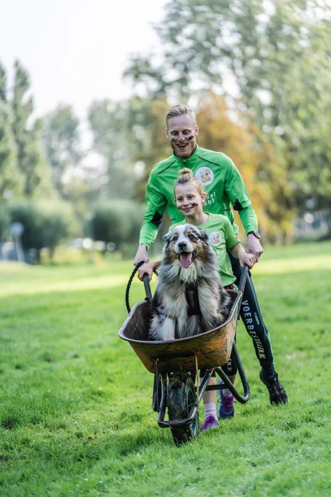 Kevin duwt met zijn dochter een kruiwagen waar de hond in zit